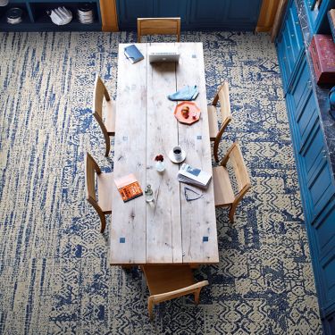 Interface PM37 and PM01 plank carpet tile with PM38 carpet tile in overhead view of seating area with wooden table and chairs