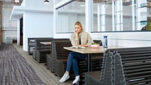 Interface Luminescent plank carpet tile in cafe area with woman seated at table