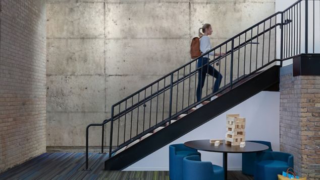 Interface Translucent and Aglow plank carpet tile in open area with man climbing stairs