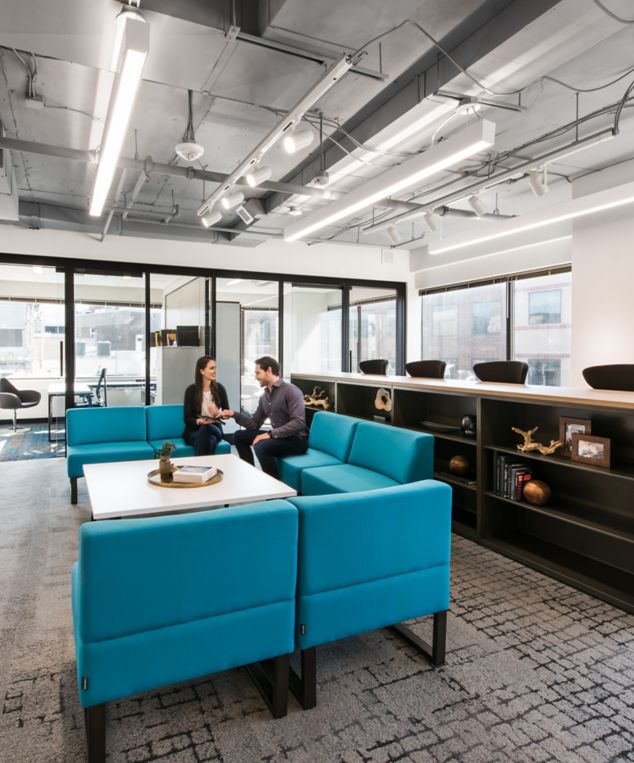 Interface Flagstone and Sett in Stone carpet tile in seating area with blue chairs and white table