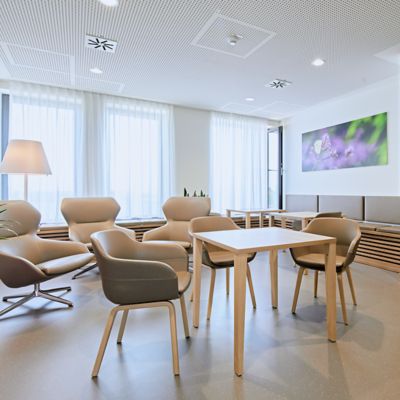 nora by Interface rubber flooring in lounge area with wooden furniture and moss wall