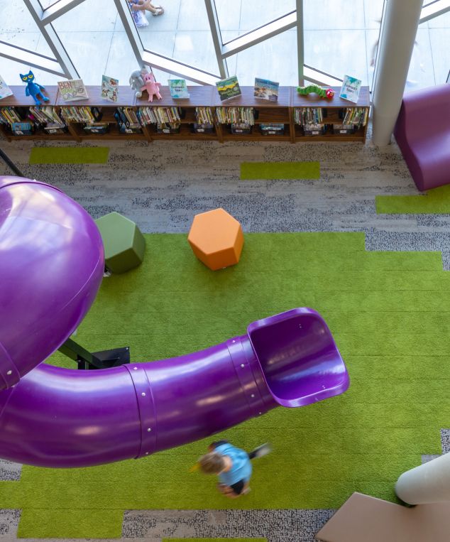 Interface, HN830, HN840 and HN850 plank carpet tile in K-12 library with coiled purple slide