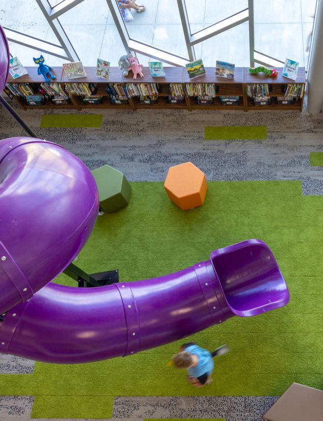 Interface, HN830, HN840 and HN850 plank carpet tile in K-12 library with coiled purple slide