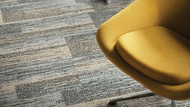 Close-up of Interface AE313 plank carpet tile with yellow chair