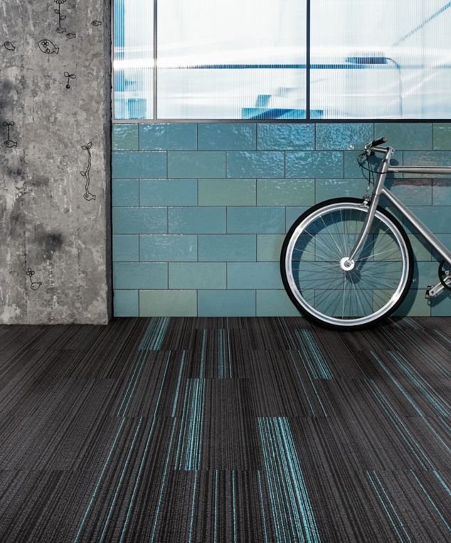 Interface BP410 and BP411 plank carpet tile in open space with bicycle and exposed brick wall