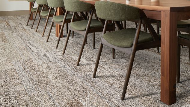 Interface Eben plank carpet tile in dining area with long wood table and upholstered chairs