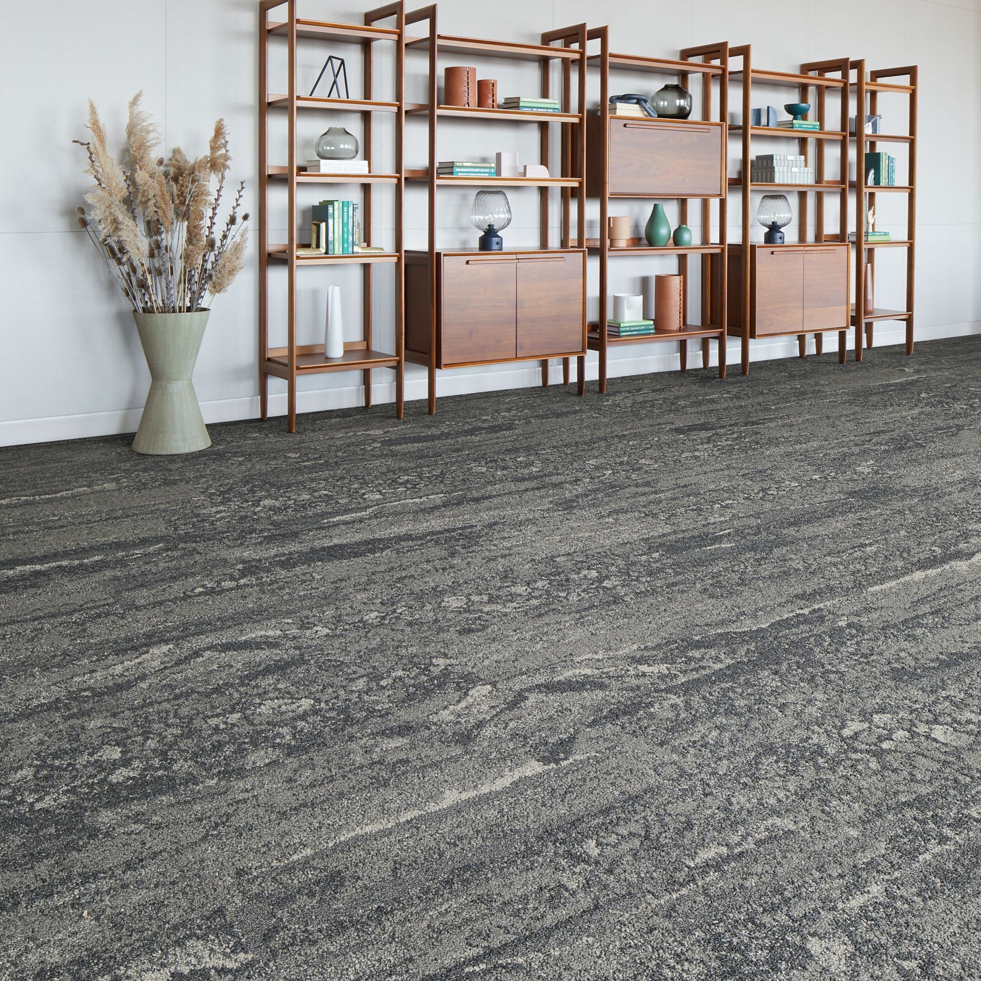 Interface Ferris plank carpet tile in lobby area with bookcases and large plant