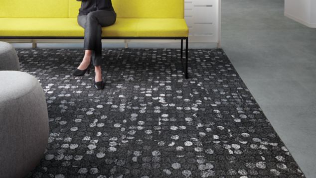 Interface Broome Street carpet tile in waiting area with woman on yellow couch