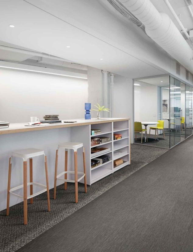 Interface Reade Street carpet tile with Brushed Lines LVT in office corridor with high table, stools and a series of small meeting rooms