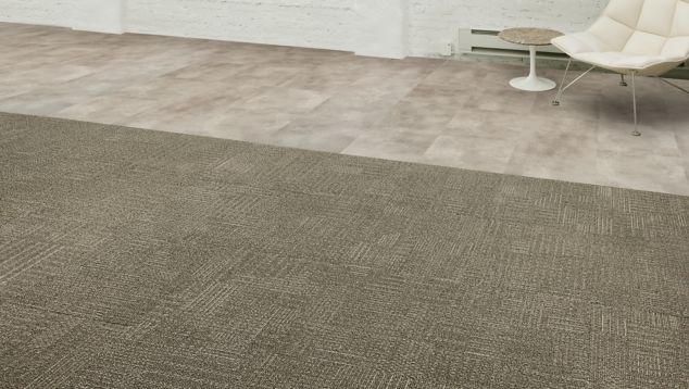 Interface CT101 carpet tile and Textured Stones LVT in open area with concrete walls and chair