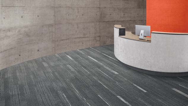 Interface Duo and Trio plank carpet tile in receptionist area with concrete walls