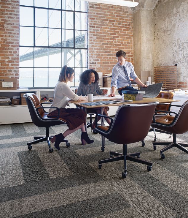 Interface EM551 plank carpet tile in open room with people meeting around wood table