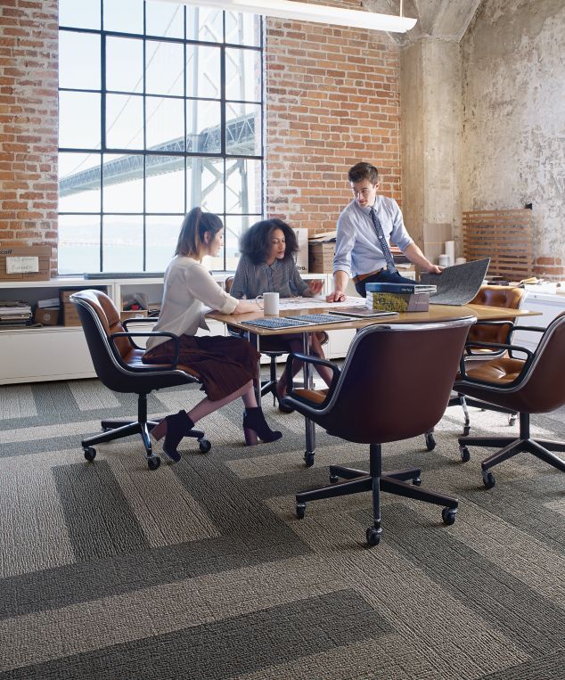 Interface EM551 plank carpet tile in open room with people meeting around wood table