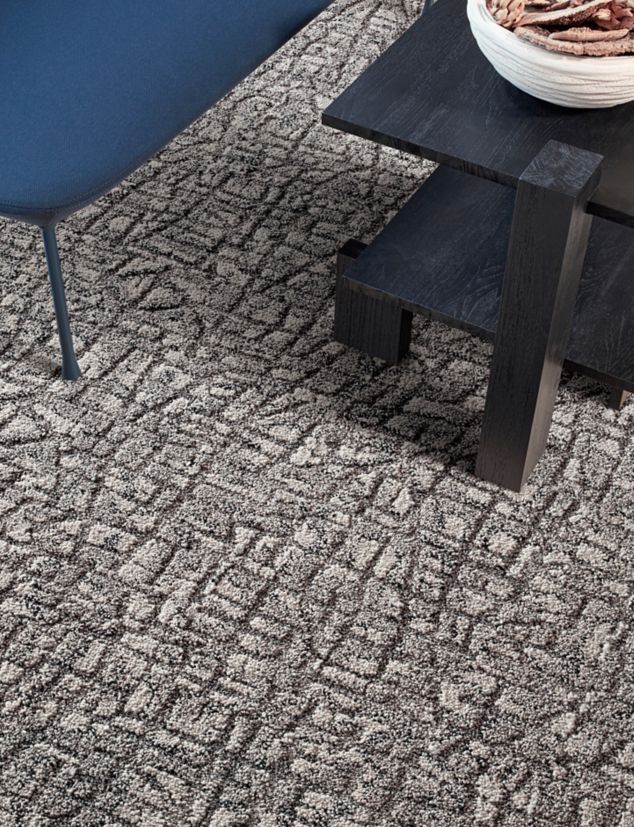 Interface E610 carpet tile in lobby with blue bench and dark wood table