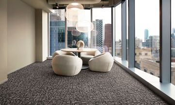 Interface E610 carpet tile in modern office meeting area with small table and low chairs