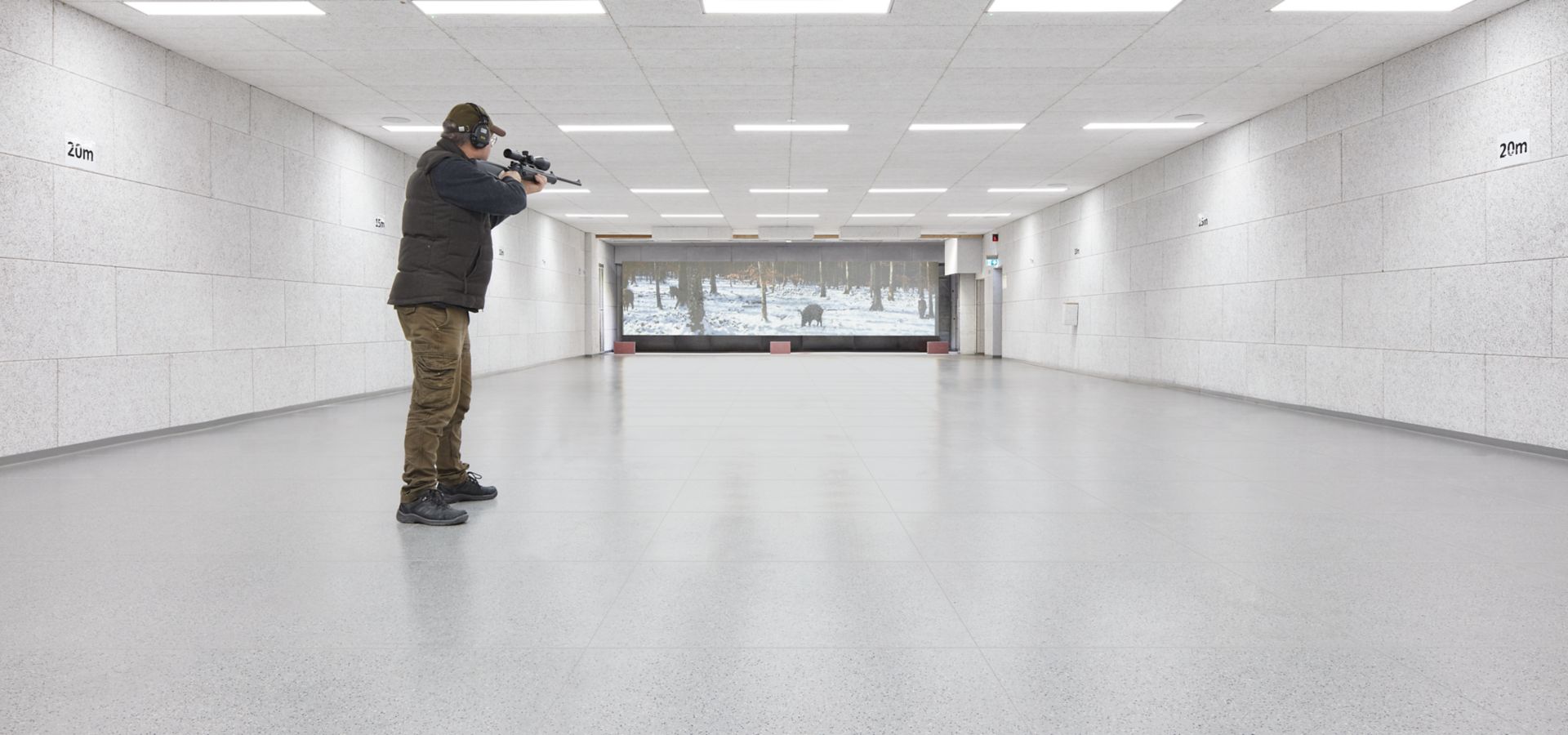man practising in an indoor shooting range