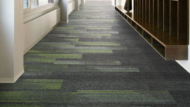 Interface Ground Waves Verse plank carpet tile in corridor with shelves lining one wall