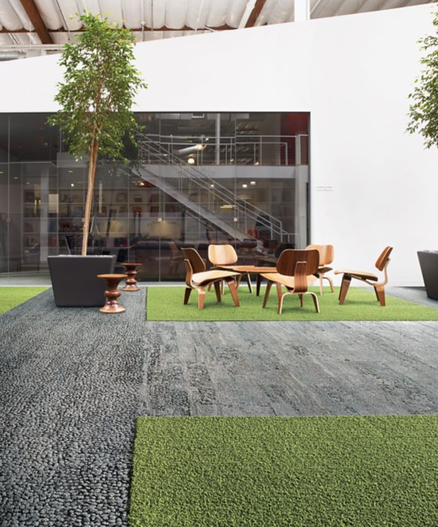 Interface HN810, HN830, HN840 and HN850 plank carpet tiles in open area with wood table and chairs and stairwell in the background