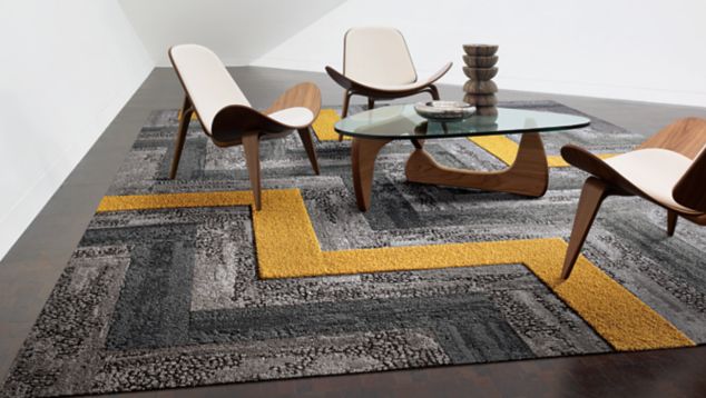 Interface HN810, HN830 and HN850 plank carpet tiles in white room with stacked rocks on glass table