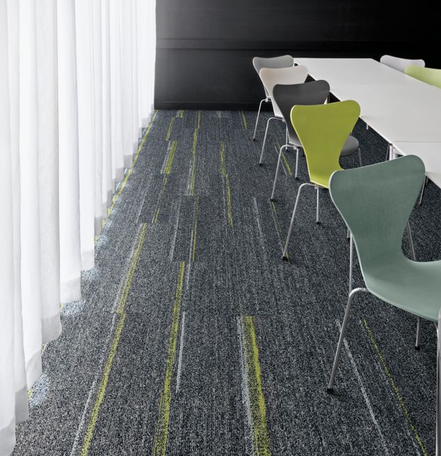 Interface Harmonize and Ground Waves plank carpet tile with multi-colored chairs at long table