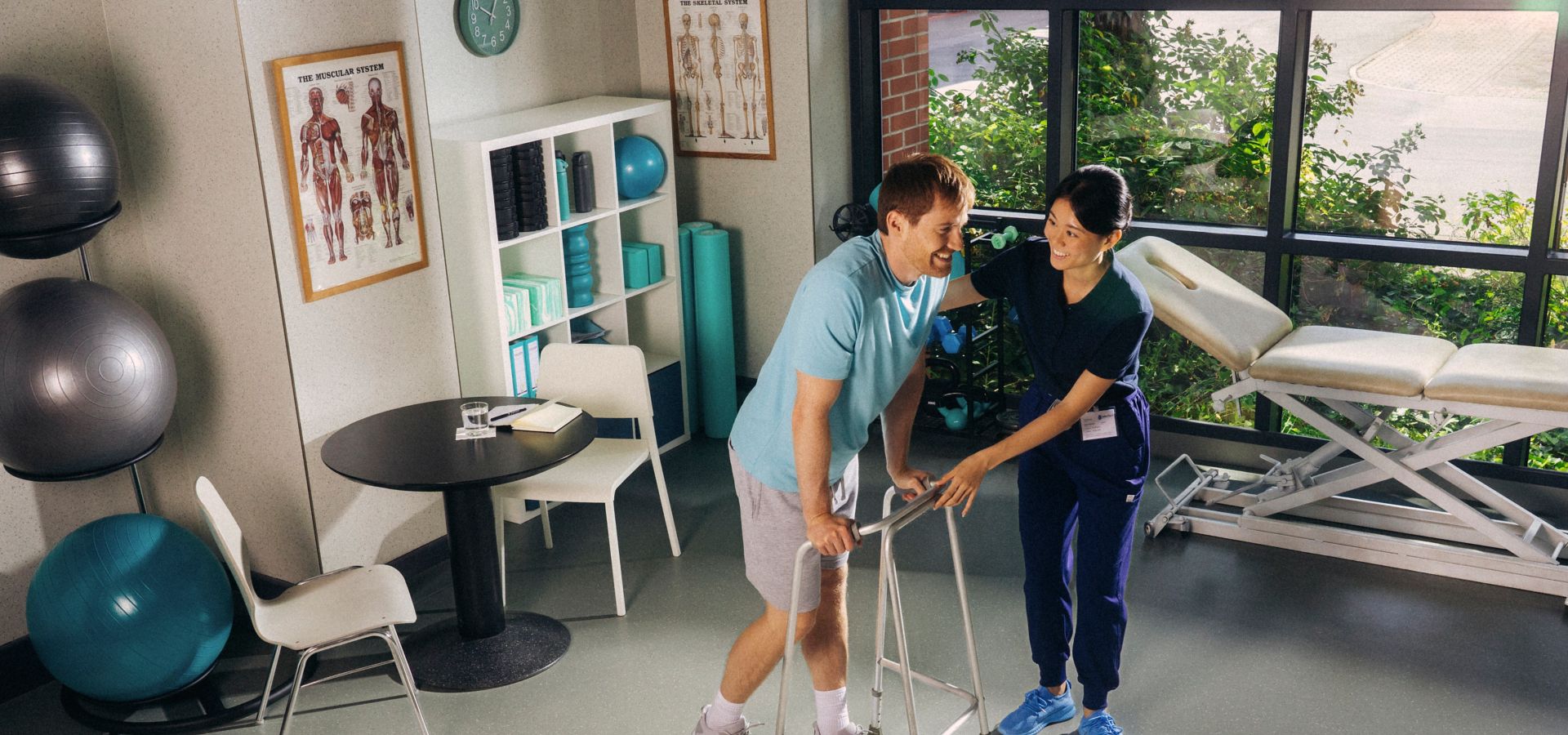 Physical therapy room with rubber flooring and therapist helping patient