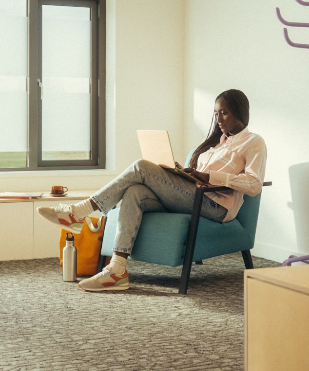 Interface E610 carpet tile in office with woman working on laptop