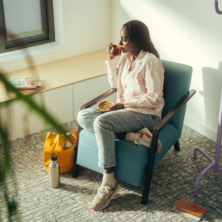 Interface E610 carpet tile with woman seated and looking out a window