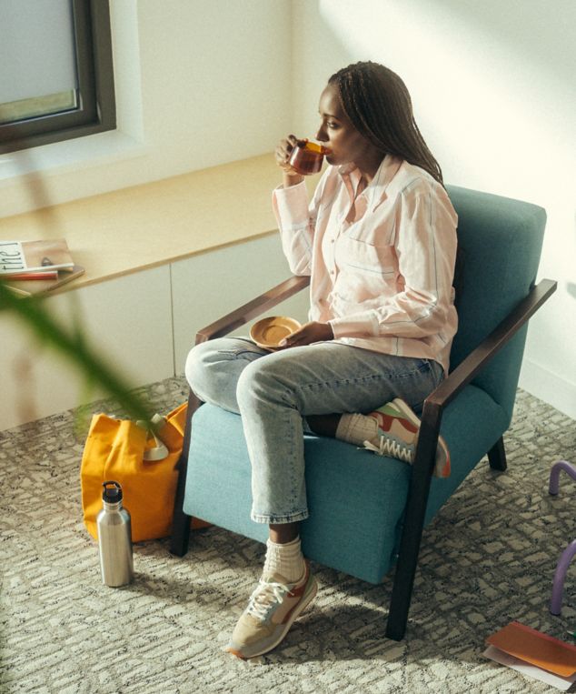 Interface E610 carpet tile with woman seated and looking out a window