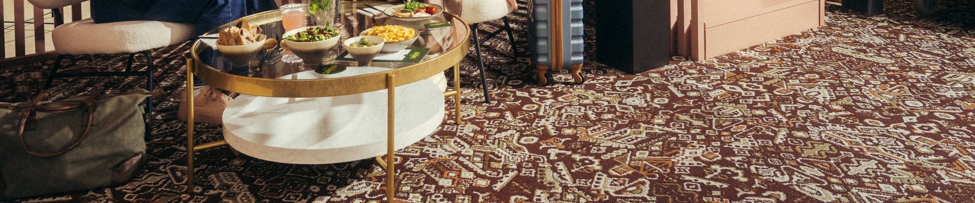 Interface Reeling carpet tile in hospitality lobby with two women chatting and eating