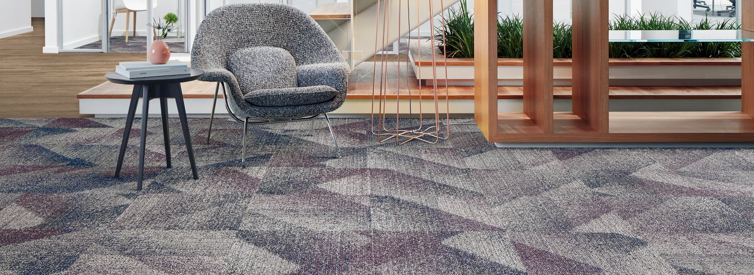 Interface Light Play carpet tile with On Grain plank LVT in office lobby with woman climbing steps