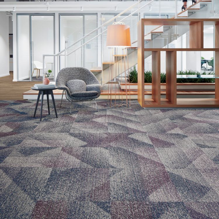 Interface Light Play carpet tile with On Grain plank LVT in office lobby with woman climbing steps