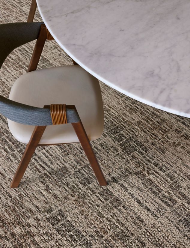 Interface Skylights plank carpet tile in close-up shot of table and chair