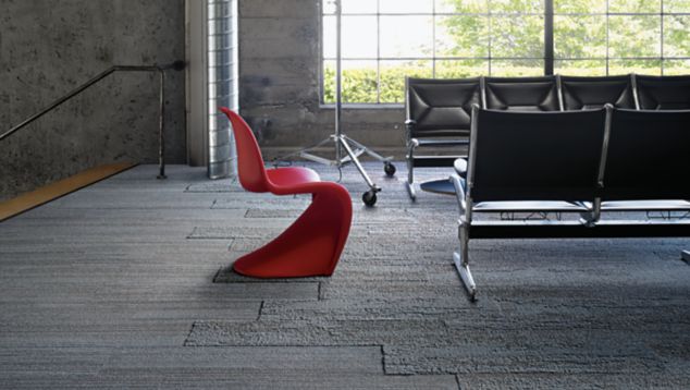 Interface NF400 and NF401 plank carpet tile in public space with black beam seating plus red chair and large window