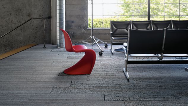 Interface NF400 and NF401 plank carpet tile in public space with black beam seating plus red chair and large window