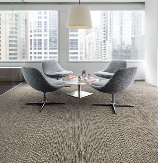 Interface Night Flight carpet tile in office sitting area with large windows and city view