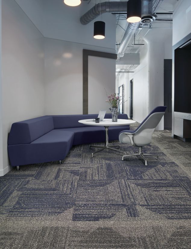 Interface Open Air 403 carpet tile with rounded blue corner bench with flower vase on table