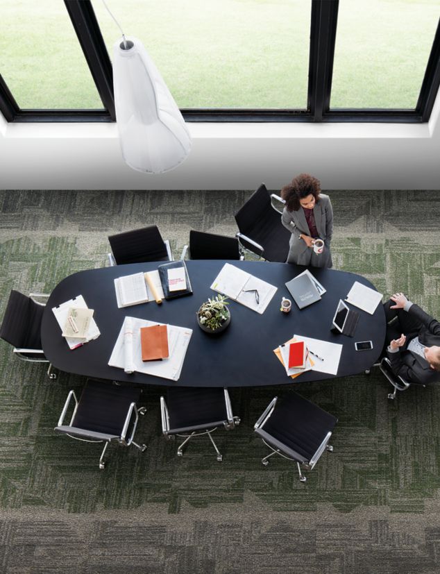 Interface Open Air 403 carpet tile in overhead view of meeting table with man and woman talking