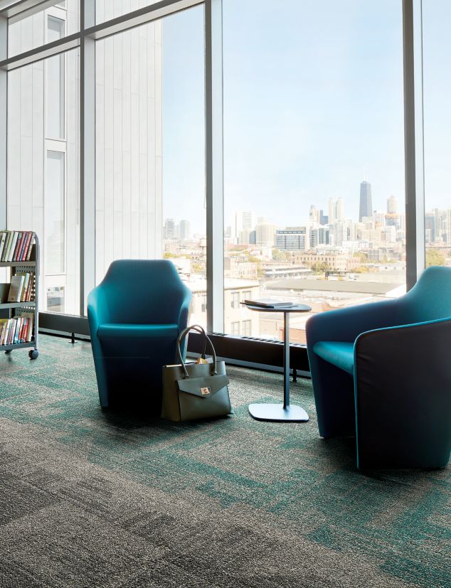 Interface Open Air 403 carpet tile in library with cement columns and city skyline in background through windows