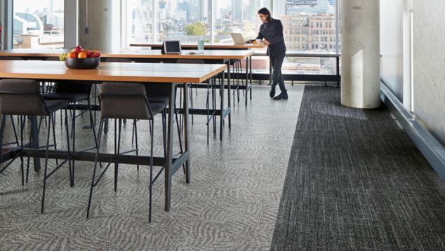 Interface Open Air 401 and 422 carpet tile in dining area with wood tables and man with laptop