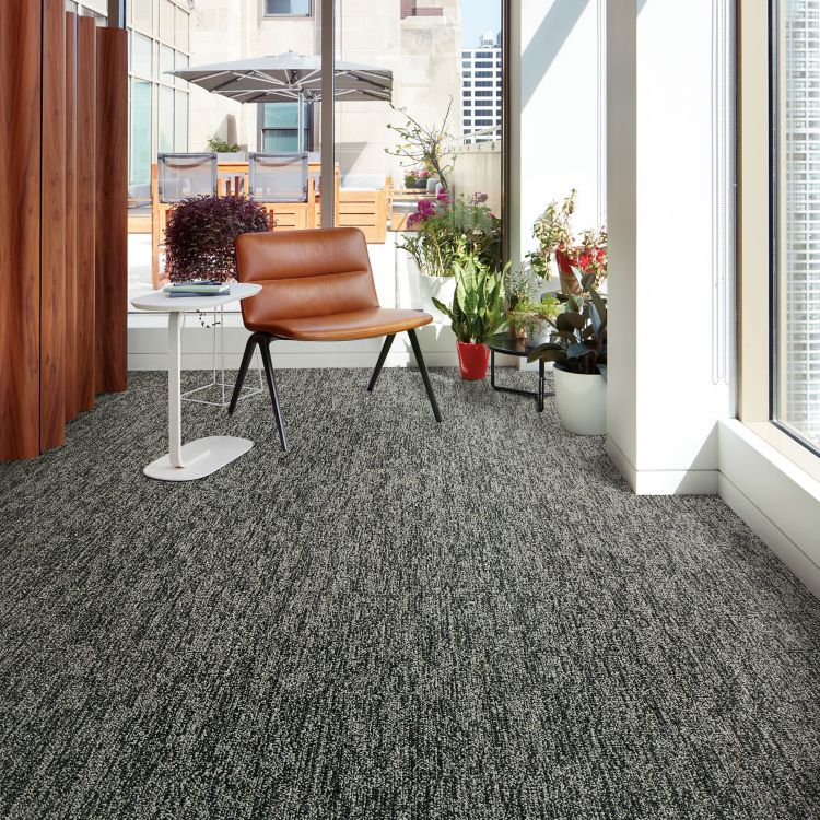 Interface Obligato plank carpet tile with leather chair and potted plants in windows