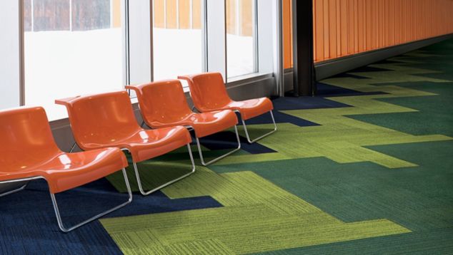 Interface On Line plank carpet tile in waiting area with orange hard plastic chairs against windows