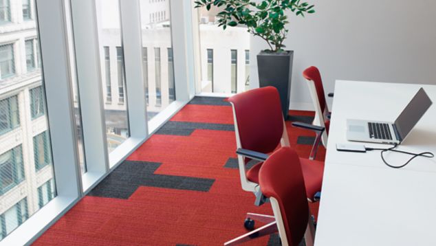 Interface On Line plank carpet tile in corner working space with angled windows overlooking highrise office buildings