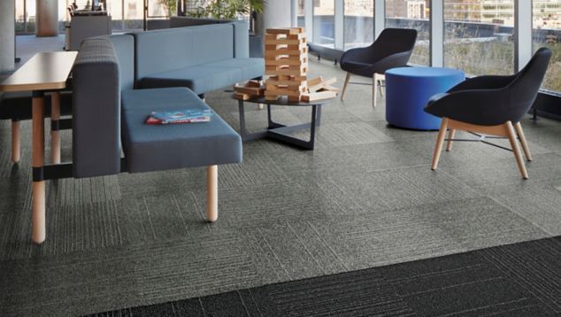 Interface Open Air 423 carpet tile in social space with blue seating and floor to ceiling windows