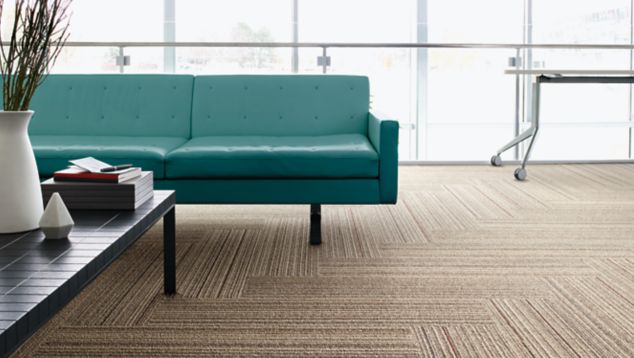 Interface SL920 plank carpet tile in seating area with green couch
