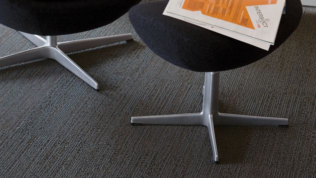 Detail of Interface San Roco carpet tile with chair and ottoman