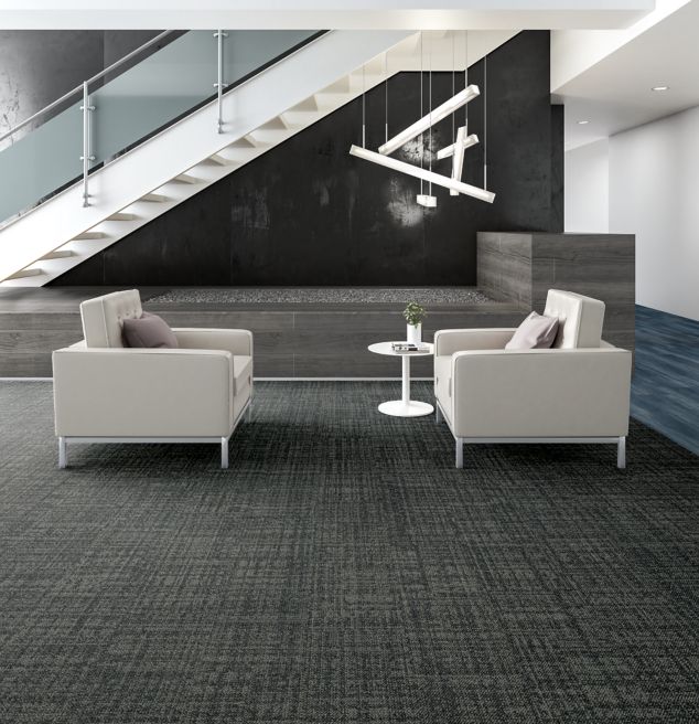Interface Source Material plank carpet tile and Studio Set plank LVT in lobby with two white chairs and stairs
